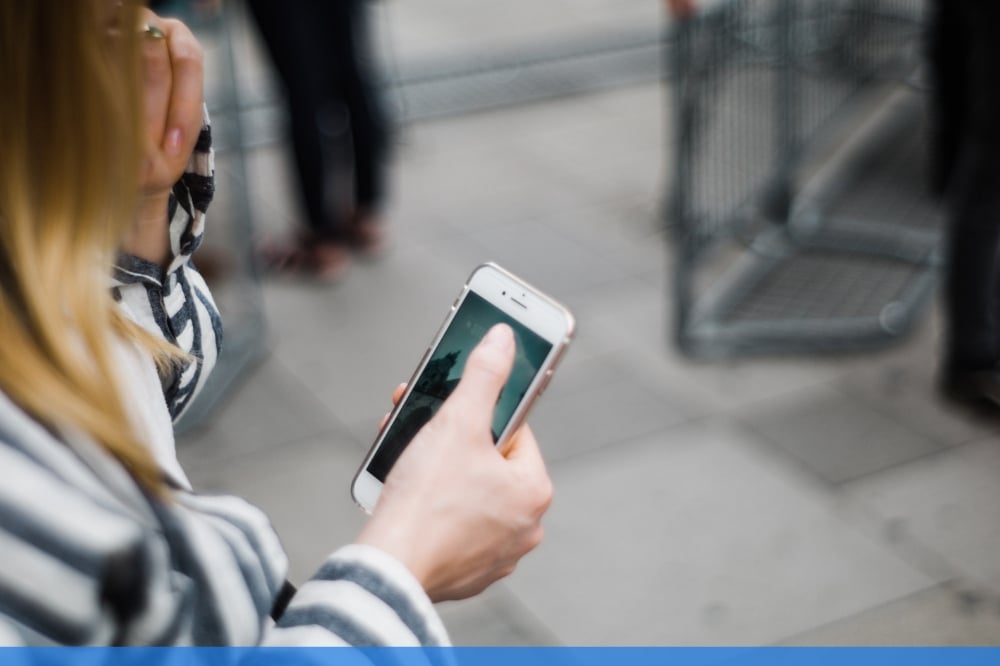 close up of a young girl scrolling through her mobile phone