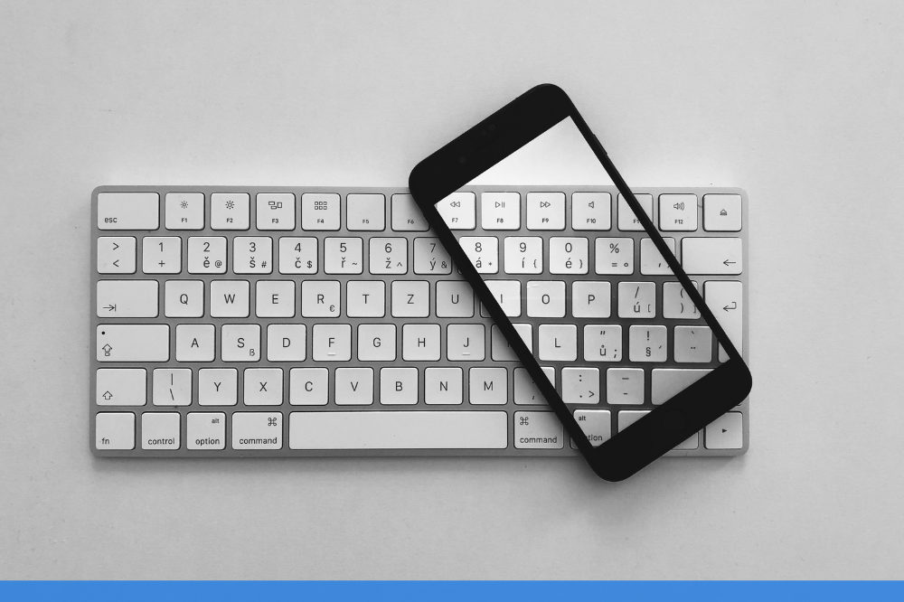 closed up of mobile resting on a white keyboard